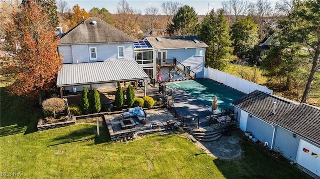 rear view of house with a lawn, a patio area, outdoor lounge area, and a covered pool