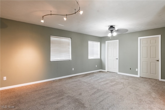 spare room with carpet, rail lighting, and ceiling fan