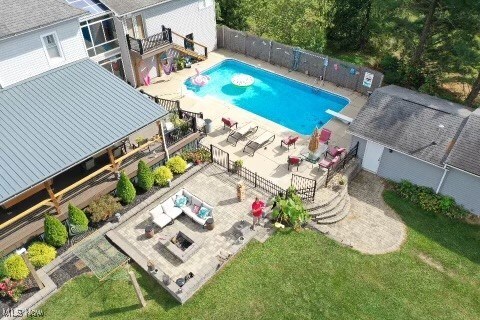 view of swimming pool featuring a yard, a diving board, and a patio area