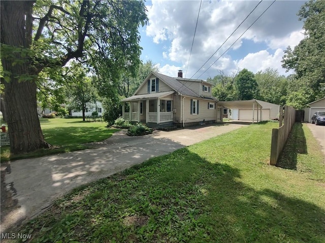 rear view of property featuring a porch, a yard, and a garage