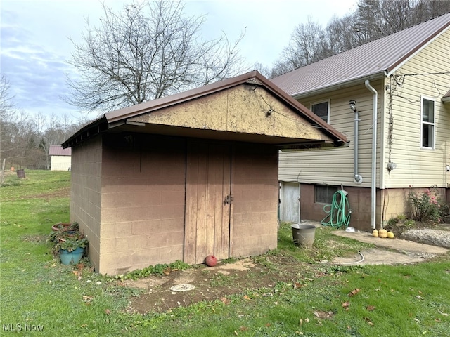 view of side of home with a lawn and a shed