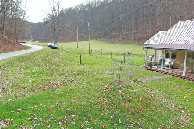 view of yard with covered porch and a wooden deck
