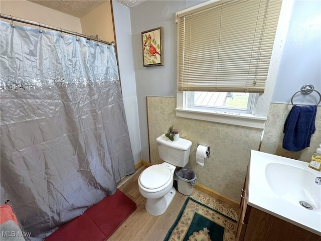bathroom featuring vanity, hardwood / wood-style flooring, a shower with shower curtain, toilet, and a textured ceiling