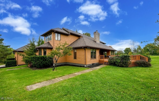 back of property featuring a deck and a lawn