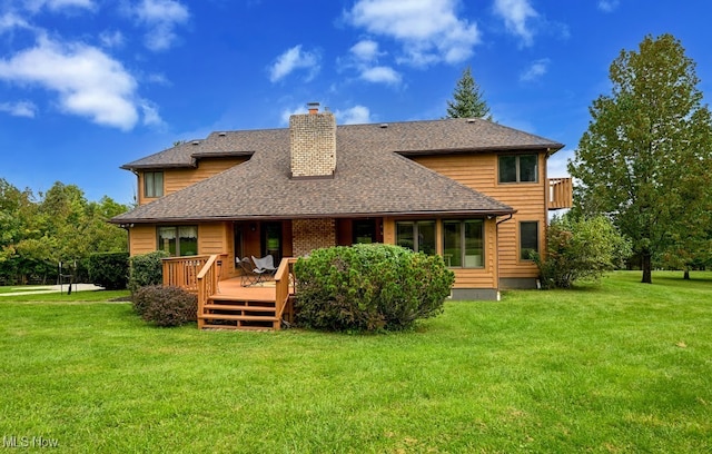 back of property with a yard and a wooden deck