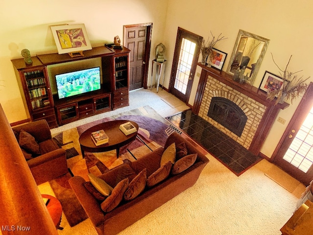 living room featuring carpet and a brick fireplace