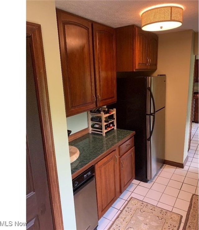 kitchen with stainless steel fridge, light tile patterned floors, and a textured ceiling