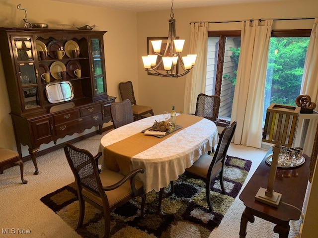 carpeted dining area featuring a notable chandelier