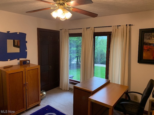 office space featuring ceiling fan, a textured ceiling, and light carpet