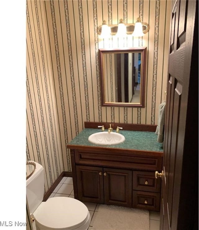 bathroom with tile patterned flooring, vanity, and toilet