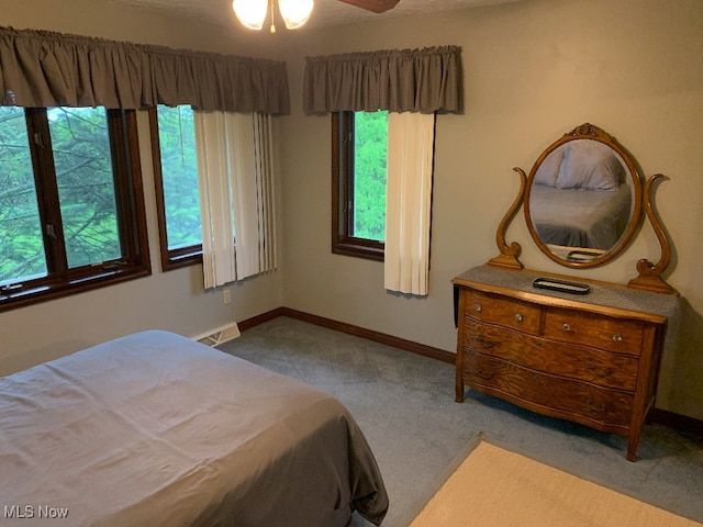 bedroom featuring ceiling fan, light carpet, and multiple windows