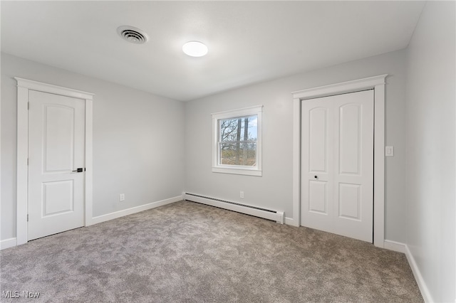 unfurnished bedroom featuring light carpet and a baseboard radiator