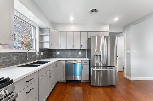 kitchen featuring appliances with stainless steel finishes, dark hardwood / wood-style floors, tasteful backsplash, and sink