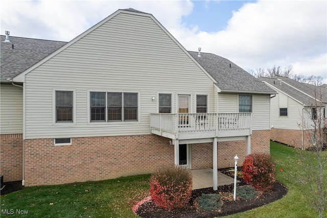 rear view of house featuring a lawn, a patio area, and a wooden deck