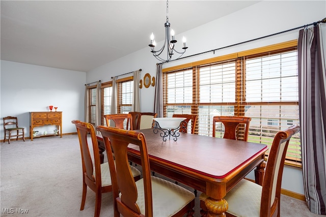 dining room with light colored carpet and a notable chandelier