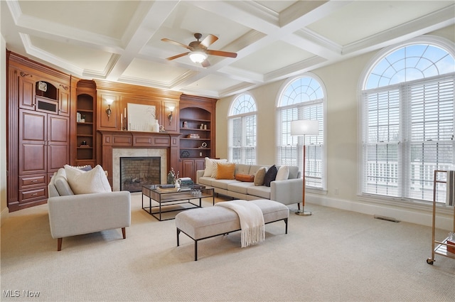 carpeted living room featuring built in shelves, a healthy amount of sunlight, and beam ceiling