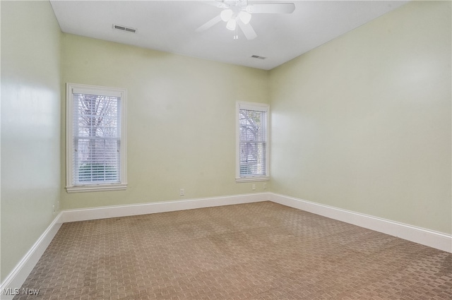 carpeted spare room featuring ceiling fan