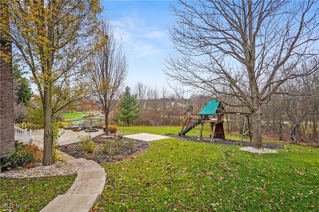 view of yard featuring a playground and a patio