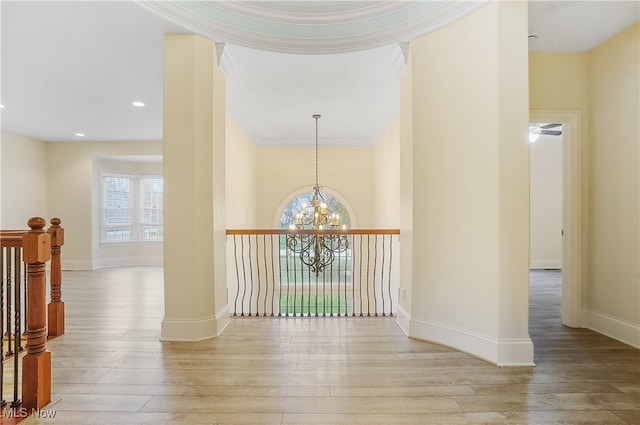 hall featuring ornamental molding, light hardwood / wood-style flooring, and a notable chandelier