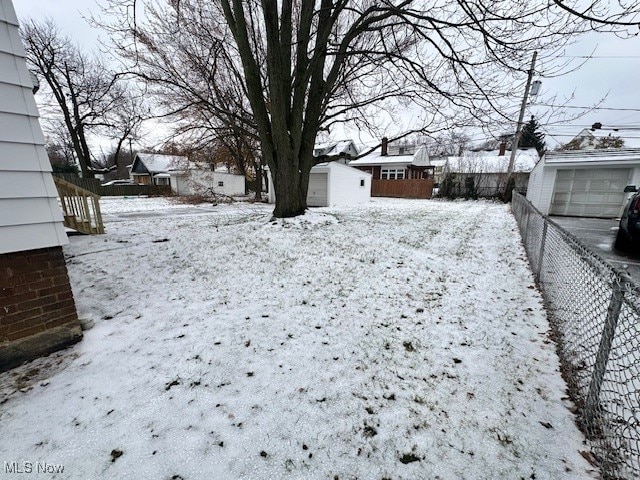 snowy yard with an outbuilding