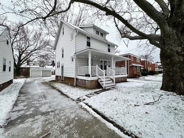 view of front facade with an outbuilding, a garage, and covered porch