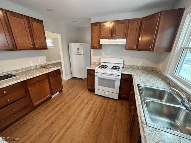 kitchen featuring sink, white appliances, and light hardwood / wood-style flooring