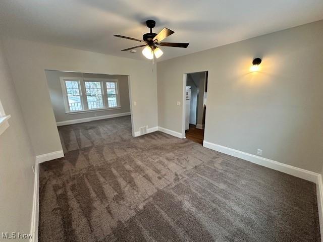 356 Babbitt Rd, Euclid, OH 44123 - empty room featuring a ceiling fan, dark colored carpet, and baseboards