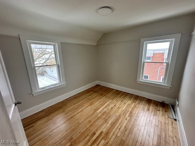 additional living space featuring light hardwood / wood-style floors and vaulted ceiling