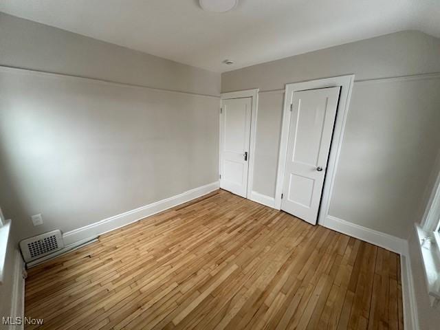 356 Babbitt Rd, Euclid, OH 44123 - unfurnished bedroom featuring light wood-style flooring, baseboards, and two closets