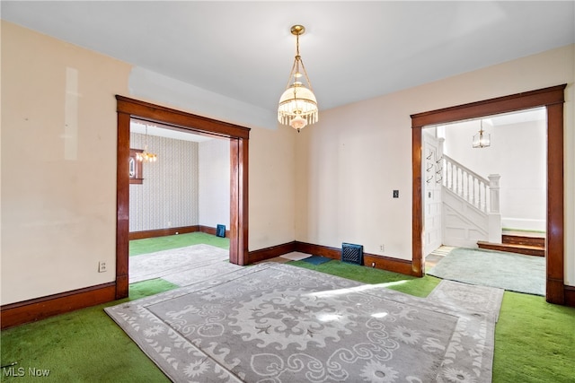 empty room with a chandelier and carpet floors