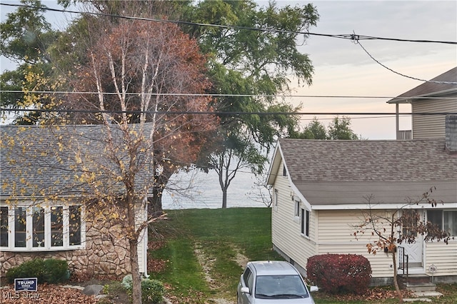 property exterior at dusk featuring a lawn