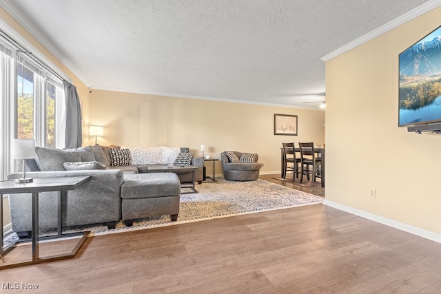 living room with hardwood / wood-style floors, a textured ceiling, ceiling fan, and ornamental molding