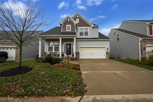 craftsman house featuring a garage, covered porch, and a front lawn