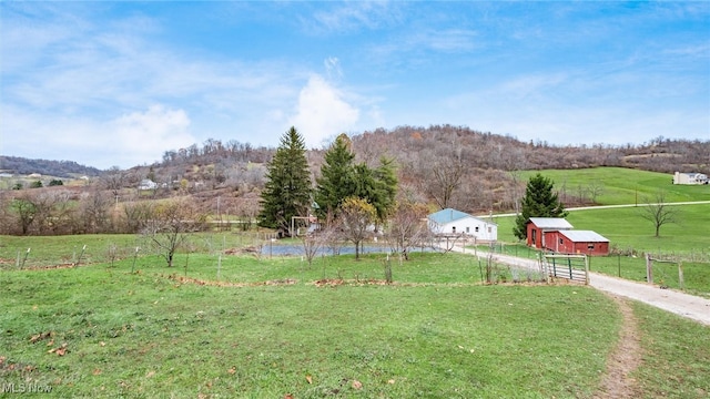 view of yard featuring a mountain view, a rural view, and an outdoor structure