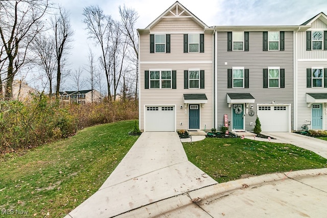 view of property featuring a garage and a front lawn