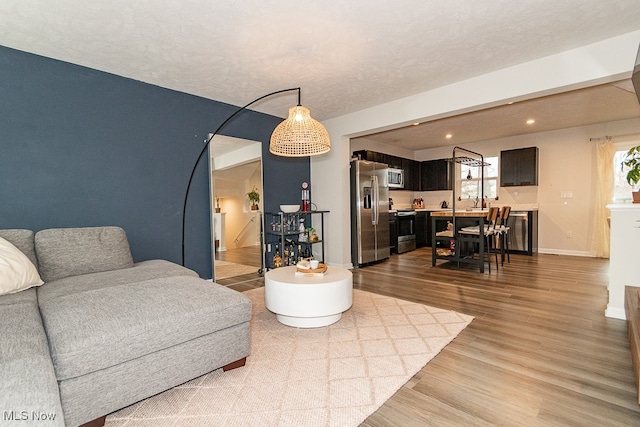 living room featuring a textured ceiling and light wood-type flooring