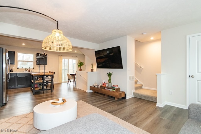 living room with sink, wood-type flooring, and a textured ceiling