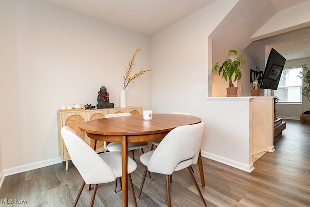 dining space featuring hardwood / wood-style flooring and lofted ceiling