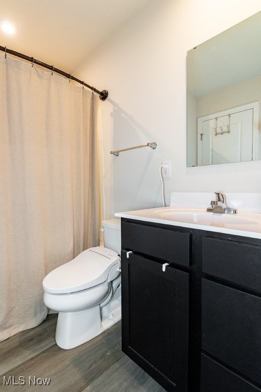 bathroom featuring vanity, hardwood / wood-style flooring, and toilet