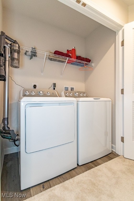 washroom featuring independent washer and dryer and light hardwood / wood-style flooring