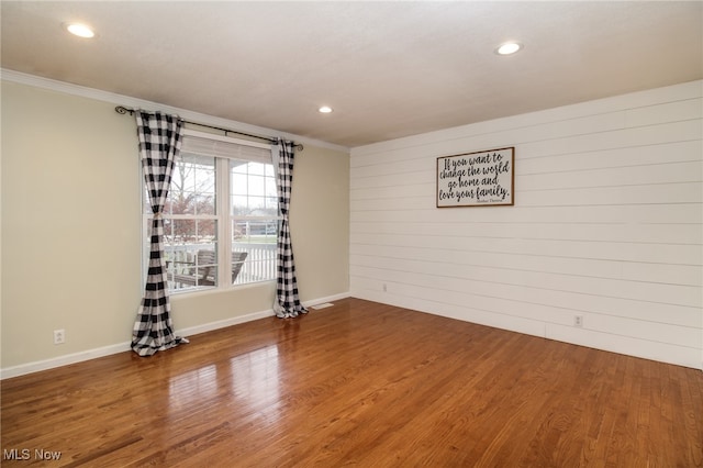 unfurnished room with hardwood / wood-style floors and crown molding