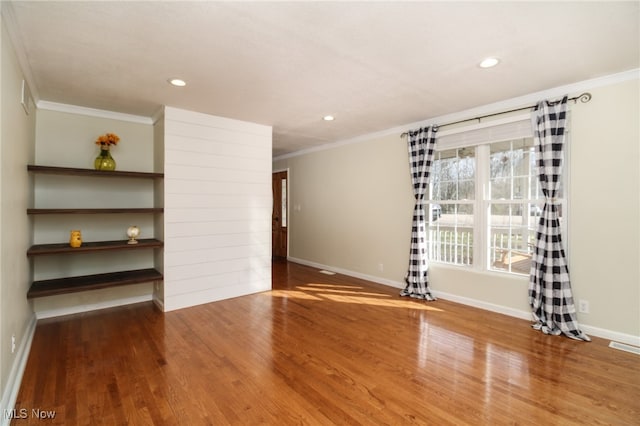 unfurnished living room featuring ornamental molding and hardwood / wood-style flooring