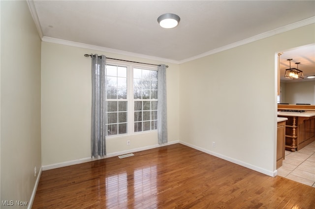 unfurnished room featuring crown molding and light hardwood / wood-style flooring