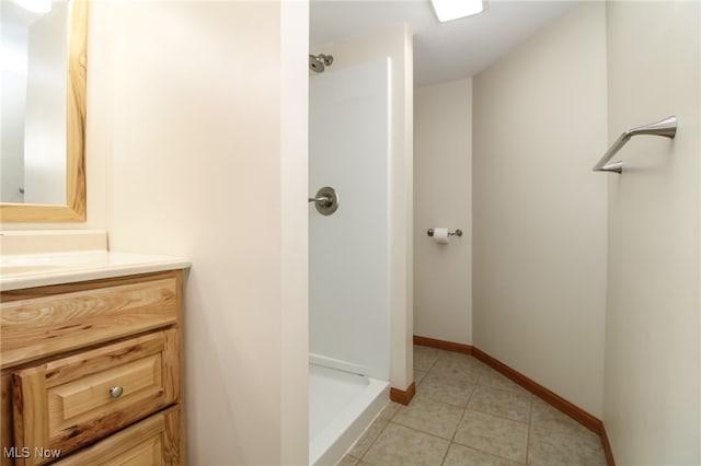 bathroom with tile patterned flooring, vanity, and walk in shower