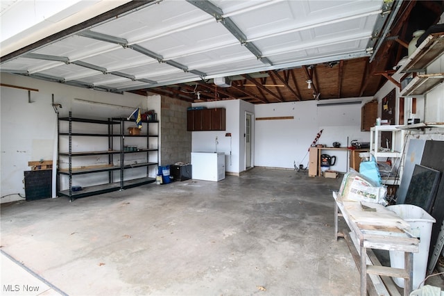 garage featuring white fridge and a garage door opener