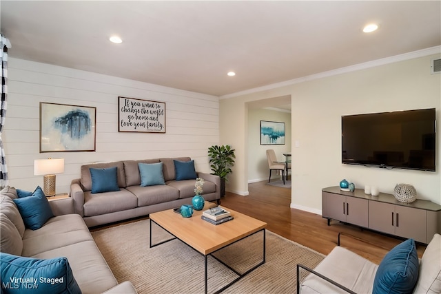 living room featuring hardwood / wood-style flooring and crown molding