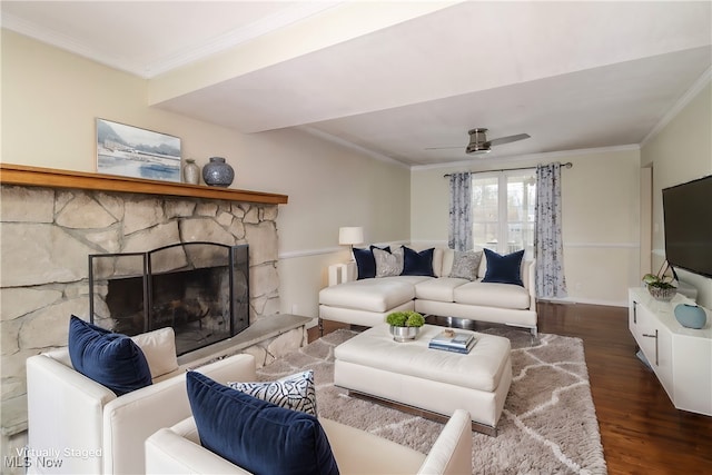 living room featuring ceiling fan, a fireplace, crown molding, and dark wood-type flooring