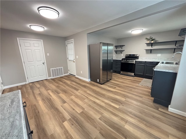 kitchen with sink, light wood-type flooring, and appliances with stainless steel finishes