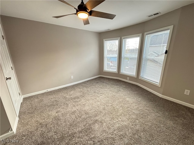 carpeted spare room featuring ceiling fan