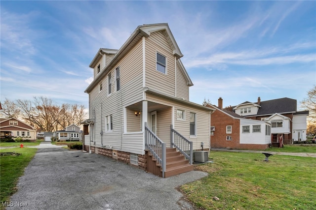 view of front facade featuring cooling unit and a front yard